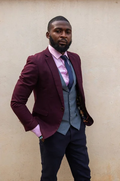 Young well-dressed model standing inside photo studio looks at photographer.