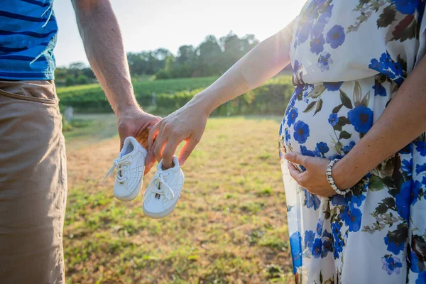 Couple Parents Holds Baby Shoes Mother Touches Her Pregnant Belly — Fotografia de Stock