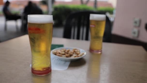 Zwei Frisch Gezapfte Biere Mit Erdnüssen Zum Aperitif Der Bar — Stockvideo