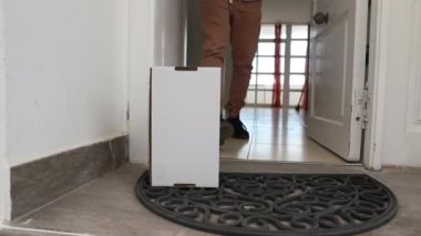 Adamın biri kapısının önünden bir paket teslim almış. Çevrimiçi alışveriş konsepti.