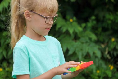 Çocuk anti-stres oyuncağıyla oynuyor. Patlat.