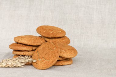 Gri kumaş arkaplanda bir yığın yulaflı kurabiye.. 