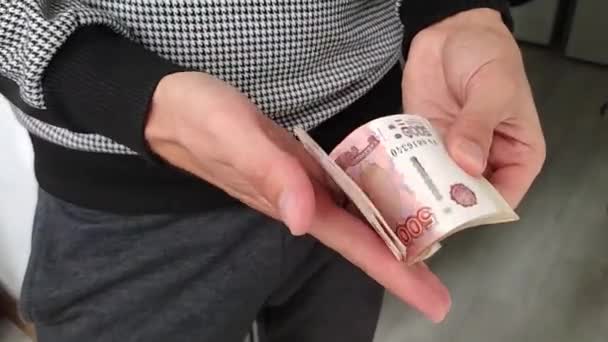 Een man heeft een hoop geld in zijn handen. — Stockvideo