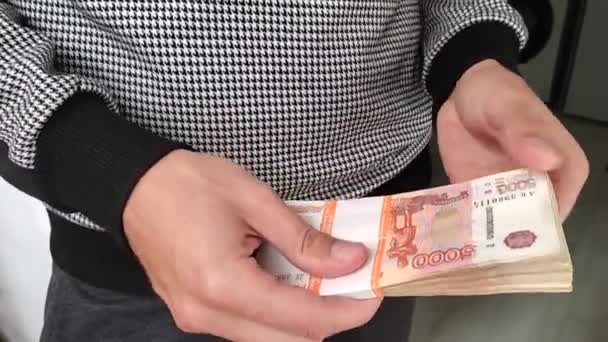 En man håller en bunt pengar i sina händer — Stockvideo