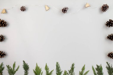 Noel arkaplanı. Gri arka planda eşkıyanın dalları ve çam kozalakları