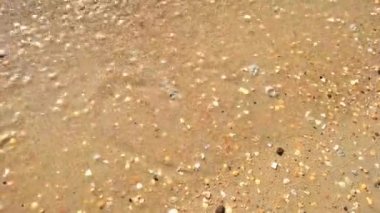 Deniz dalgası, kumlara çizilmiş aşkın sembolünü siliyor.