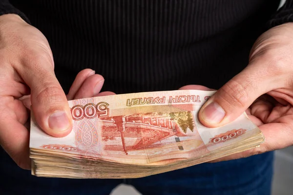 Κοντινά χέρια κρατούν ένα μάτσο ρωσικά χρήματα πέντε χιλιάδες χαρτονομίσματα.. — Φωτογραφία Αρχείου