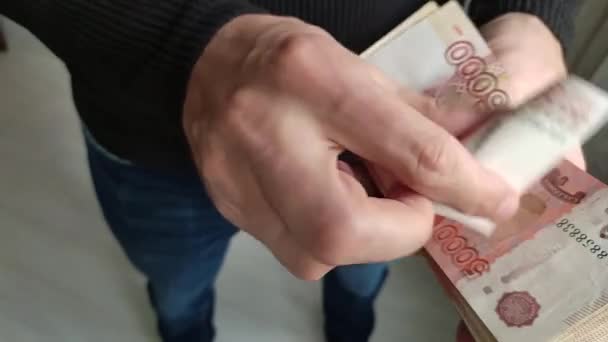 Ένας άντρας κρατάει ένα μάτσο λεφτά στα χέρια του. — Αρχείο Βίντεο