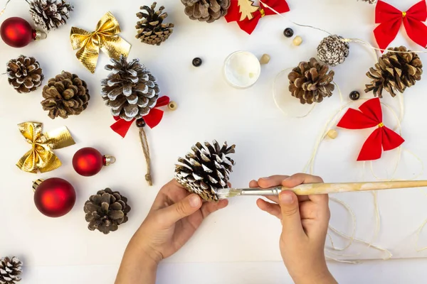 A child makes Christmas decorations with his own hands.