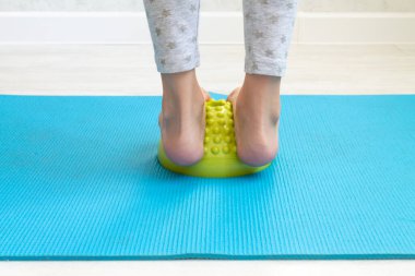 Çocuk ayak valginden yeşil dengeleyiciye egzersiz yapıyor. Childs 'ın bacakları yakın plan. Çocuklar için fizik tedavi dersleri