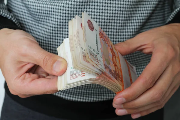 Крупным планом держат пачку русских денег пять тысяч купюр. — стоковое фото