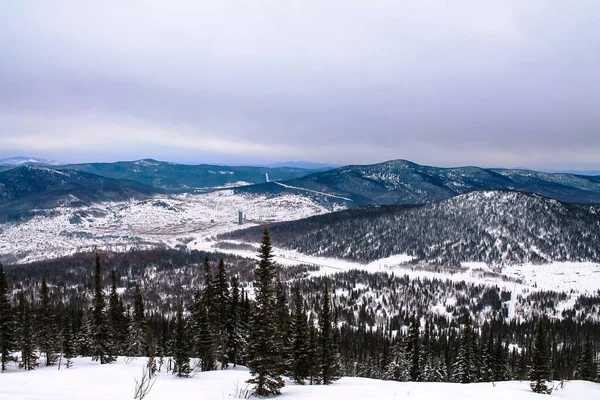 Winter landscape with snow falling, trees in snow. Sheregesh ski resort in Russia, located in Mountain Shoriya, Siberia, aerial top view. — Fotografia de Stock