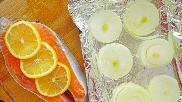 Preparation of red fish fillets with onion and lemon. Raw fish steak before baking in the oven. Salmon fish meat recipe from the chef of the restaurant.