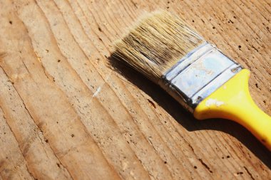 Ahşap masa arkasında boya fırçası