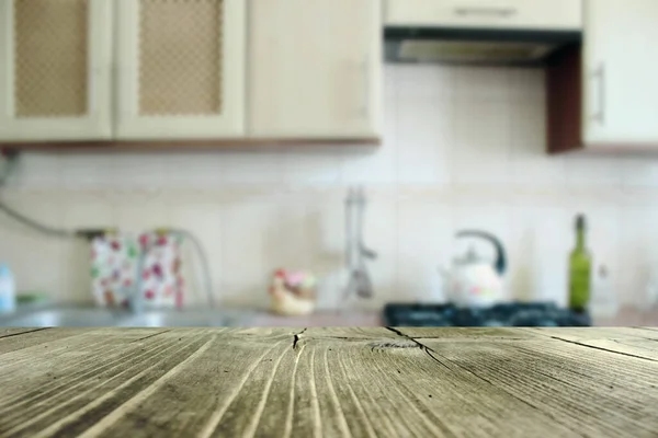Bulanık mutfakta ahşap masa üstü. Ürün görüntüleme montajını ya da görsel düzen mutfak mobilyalarını düzenle.