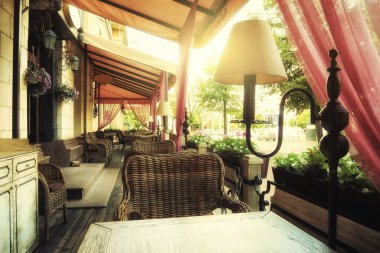 Sıcak bir yaz sabahı caddedeki açık hava kafeteryası. Sokakta güneş ışığı ve güneş ışığıyla dolu boş bir kafe.