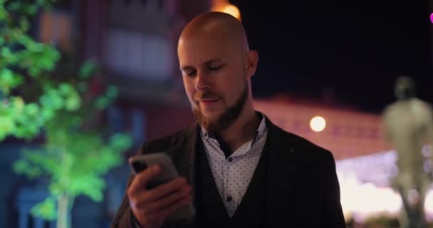 Zakenman met smartphone in de nachtstad — Stockvideo