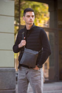 Şehirde kurye çantası tutan adam.