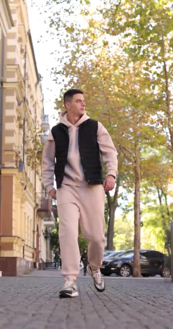 ชายในชุดสีเบจ เดินในเมือง วิดีโอแนวตั้ง — วีดีโอสต็อก