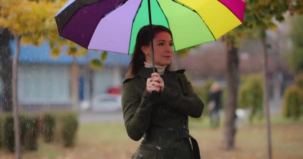 Frau versteckt sich unter Regenschirm vor dem Regen, Zeitlupe — Stockvideo