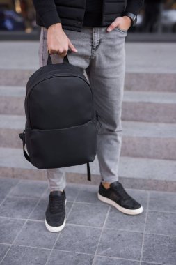 Şehirde sırt çantası tutan tanınmayan bir adam.