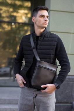 Şehirde kurye çantası tutan adam.
