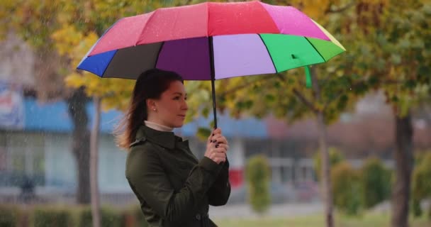 Kvinna som gömmer sig under paraply från regnet, slow motion — Stockvideo