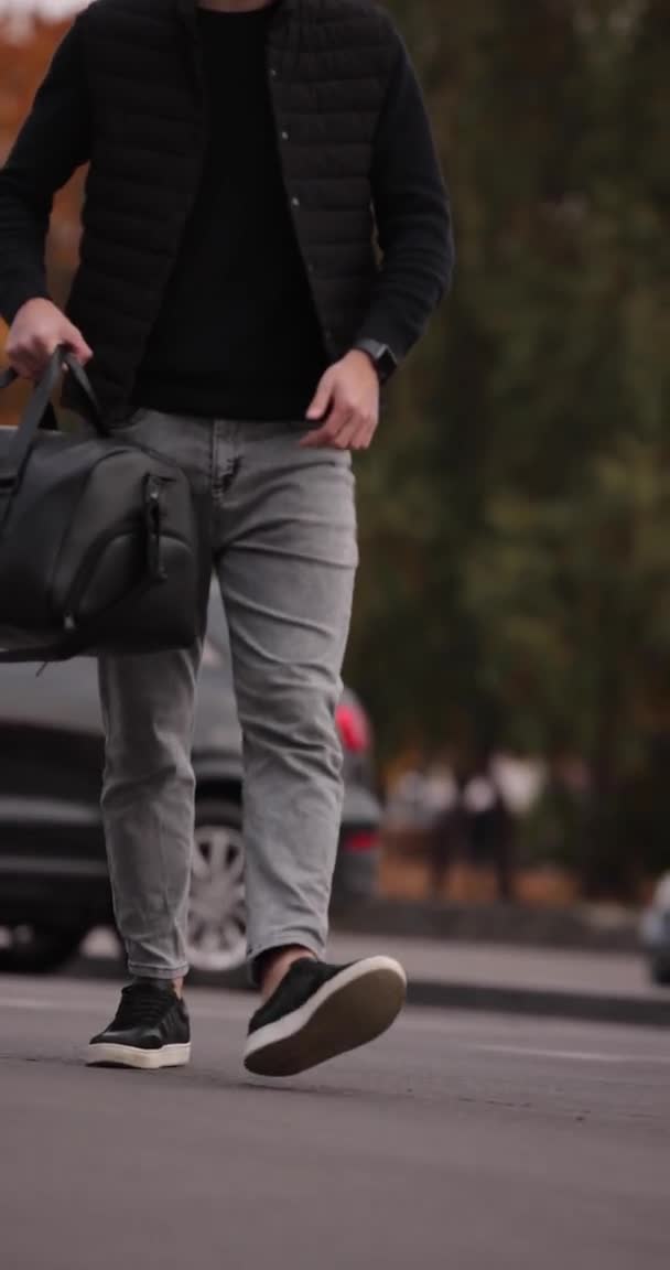 Férfi séta a városban fekete bőr táska, függőleges videó — Stock videók