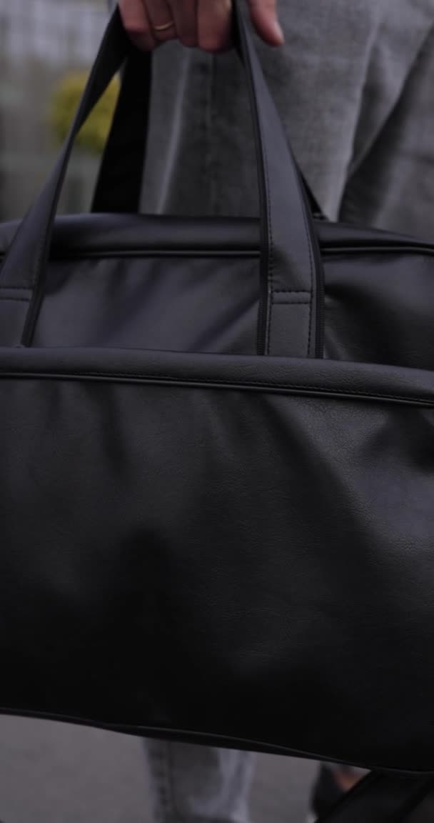 Homme marchant en ville avec sac en cuir noir, vidéo verticale — Video