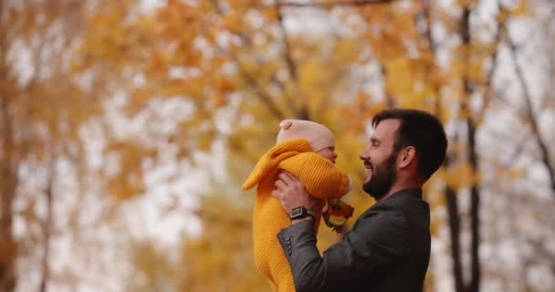 Feliz pai joga e pegar seu bebê no parque de outono — Vídeo de Stock
