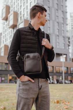 Sonbahar şehrinde kurye çantası tutan adam.