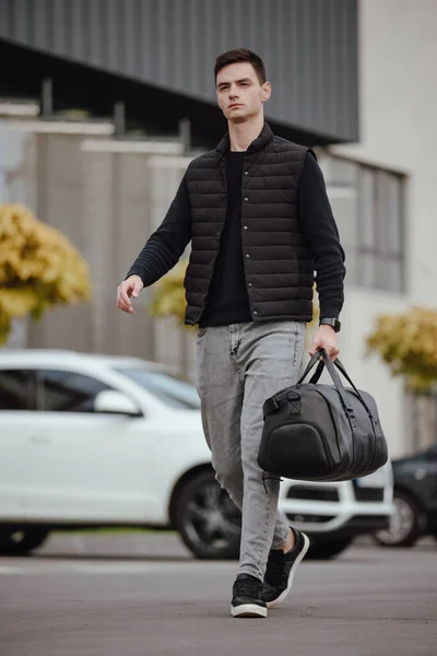 Чоловік ходить у місті з чорною шкіряною сумкою — стокове фото