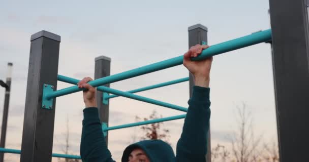 Atletický muž dělá pull-up na mříže — Stock video
