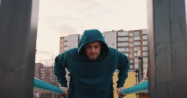 Atletik adam barlarda şınav çekiyor. 