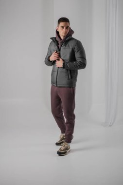 Stüdyoda siyah ceketli bir adam poz veriyor.