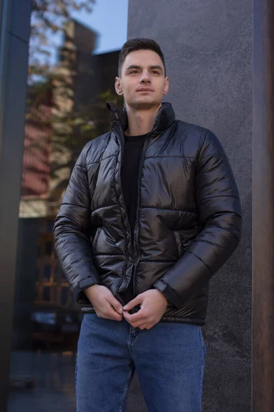 Человек, позирующий в городе в зимней куртке — стоковое фото