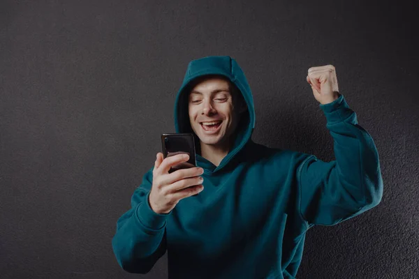 Glücklicher Mann im Kapuzenpulli mit Smartphone — Stockfoto