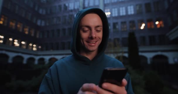 Ο άνθρωπος χρησιμοποιεί smartphone στο βράδυ της πόλης — Αρχείο Βίντεο