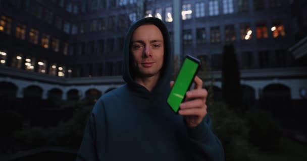 Man toont groen scherm van smartphone in de stad — Stockvideo