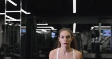 Formda bir kadın spor salonunda halterli kalçalar için egzersiz yapıyor.