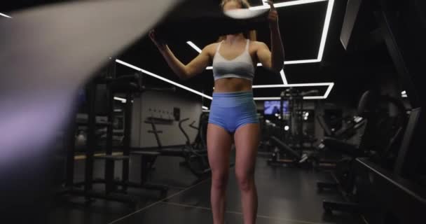 Женщина кладет коврик для йоги на пол — стоковое видео