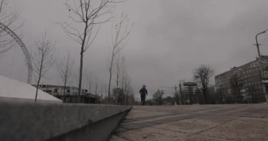 Adam şehirde ağır çekimde koşuyor.