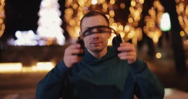 Adam kulaklıklarını takıyor.