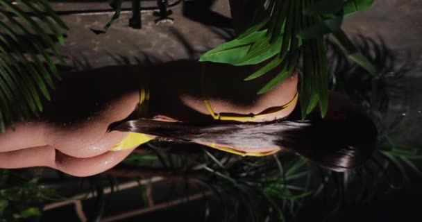 Сексуальна жінка з красивими сідницями приймає тропічний душ, вертикальне відео — стокове відео