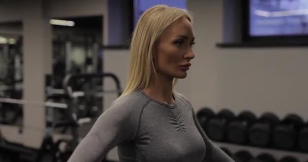 Formda bir kadın spor salonunda dambıllarla egzersiz yapıyor. — Stok video
