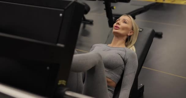 Žena cvičení na tréninkovém přístroji pro nohy — Stock video