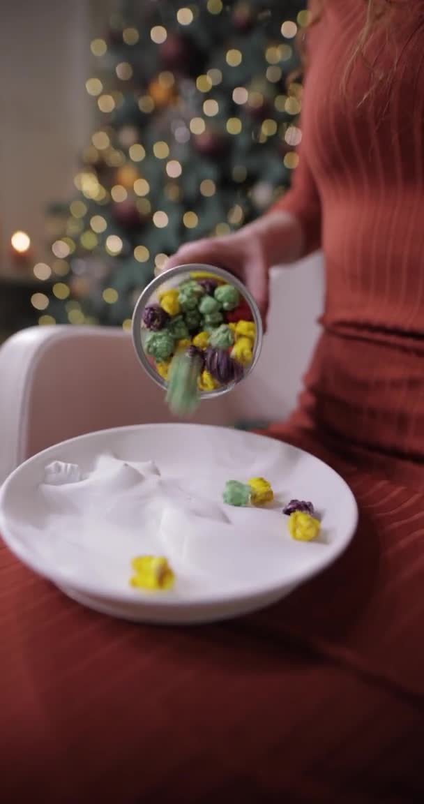 화려 한 색깔의 팝콘을 수직 영상으로 접시에 뿌려 놓는다 — 비디오