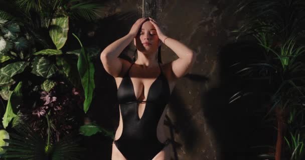 Bikinili bir kadın tropik duş altında vücudu yıkıyor, ağır çekimde. — Stok video