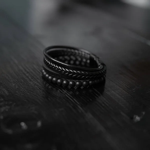 Czarna skórzana bransoletka męska na ciemnym biurku — Zdjęcie stockowe