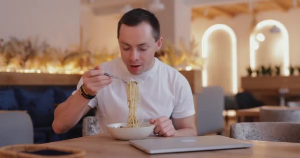 Человек ест макароны в кафе — стоковое видео